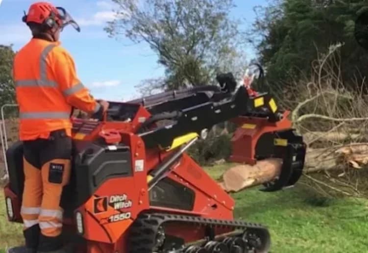 Land clearing equipment removing trees and brush from construction site for residential development